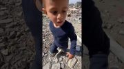 Palestinian child retrieves his tricycle from the rubble of his house in Khan Younis, Gaza